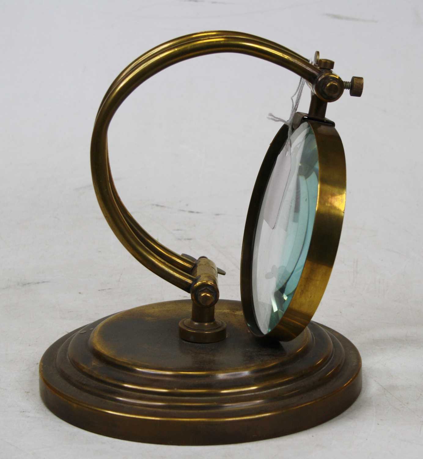 Lot 17 - A 20th century brass table magnifier on a...