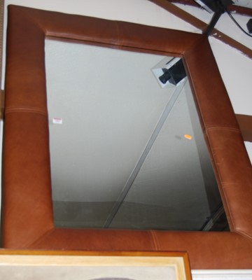 Lot 1004 - A modern wall mirror in tan leatherette...