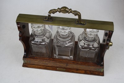 Lot 113 - An early 20th century oak three-bottle...