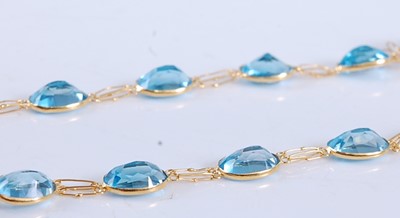 Lot 2506 - A yellow metal blue topaz necklace, comprising...