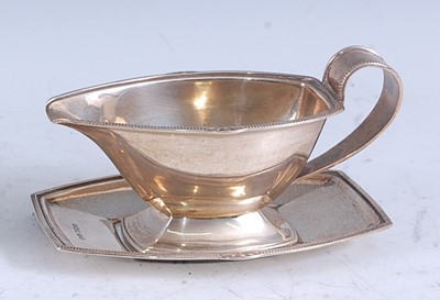 Lot 222 - An Art Deco silver sauceboat on stand, having...