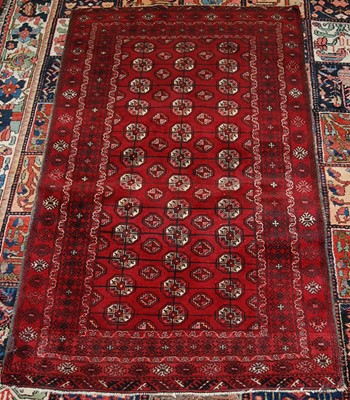 Lot 2443 - A Persian woollen Bokhara rug, the deep red...