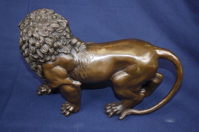 Lot 74 - A pair of bronze models of lions, each in...