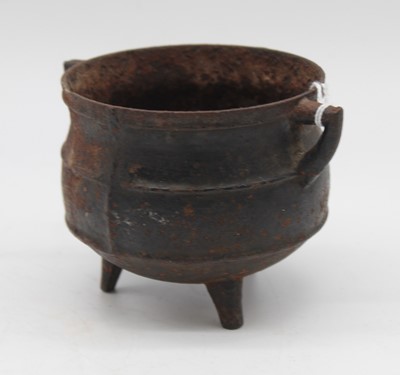 Lot 252 - A small Eastern antique iron cauldron, flanked...