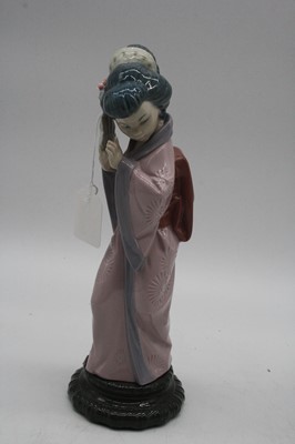 Lot 17 - A Lladro porcelain figure of a woman carrying...