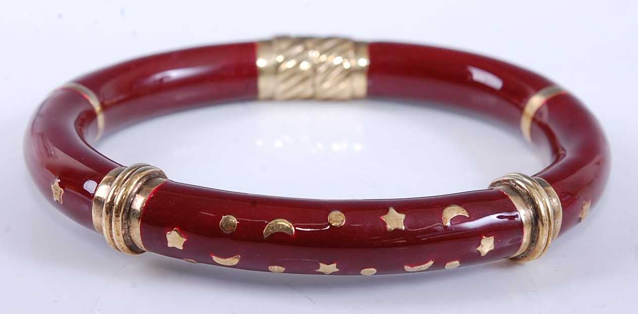 Lot 2528 - A yellow metal oval hinged hollow bangle,...