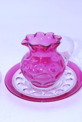 Lot 49 - A Victorian cranberry glass jug, having a...