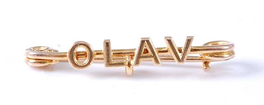Lot 2581 - A yellow metal bar brooch spelling Olav, with...