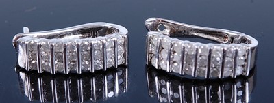 Lot 2587 - A pair of white metal diamond set hinged hoop...