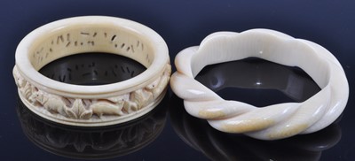 Lot 391 - An early 20th century ivory bangle with carved...
