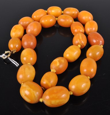Lot 311 - A beaded and knotted butterscotch amber single...