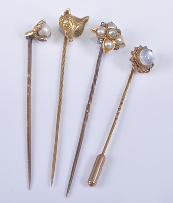 Lot 1197 - Four yellow metal stick pins, being a yellow...
