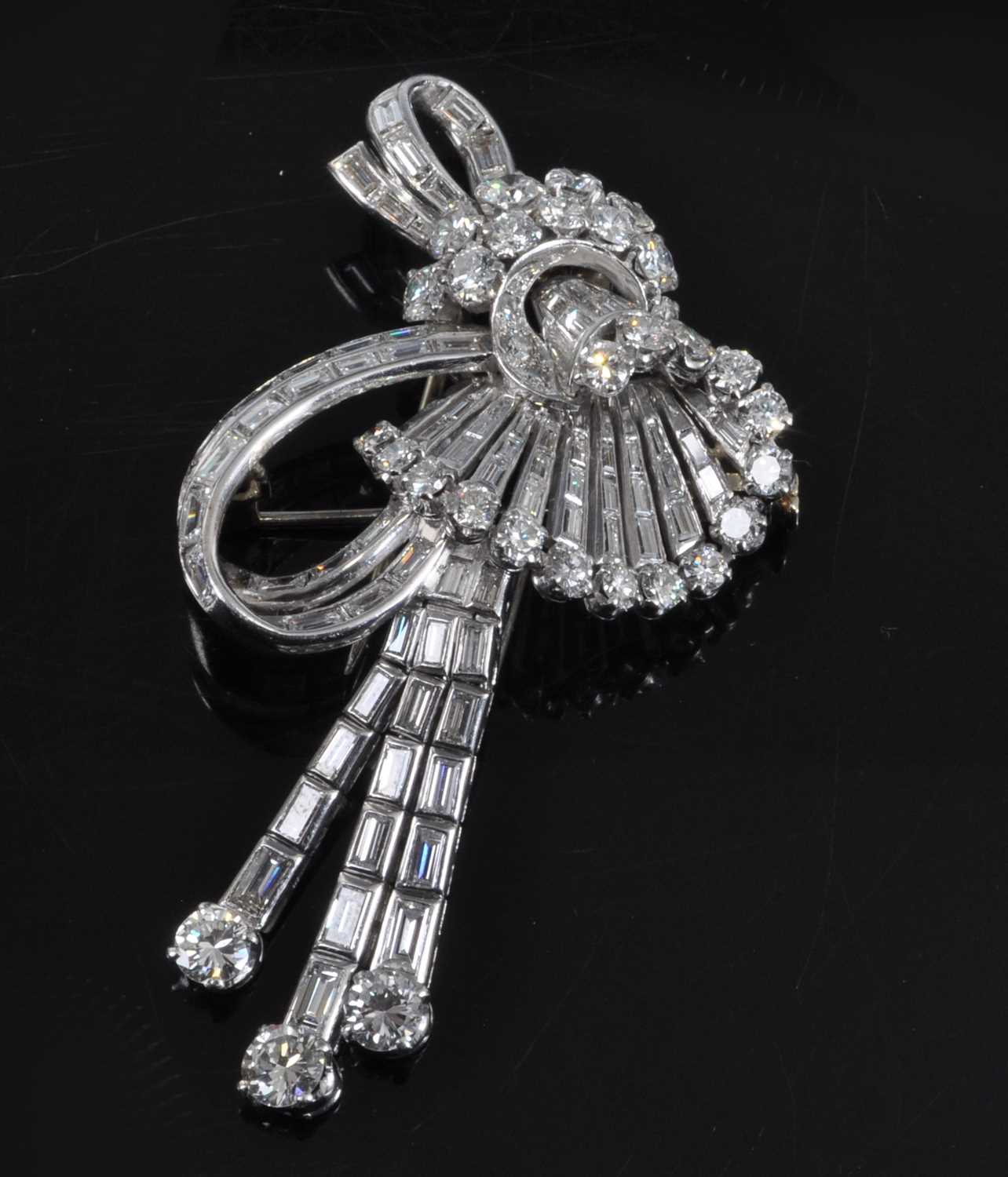 Lot 1142 - An Art Deco white metal diamond swag and bow...