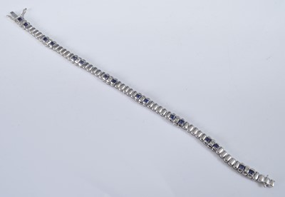 Lot 1160 - A white metal sapphire line bracelet,...