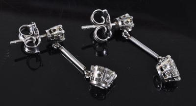 Lot 1161 - A pair of white metal diamond drop earrings,...