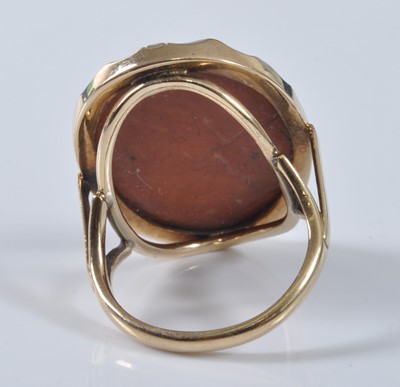 Lot 1174 - A yellow metal oval lava stone cameo ring,...