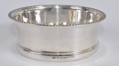 Lot 1109 - A George V silver and glass bottle coaster,...