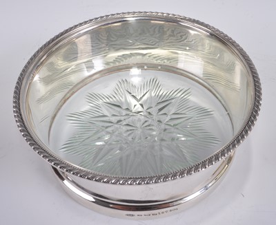 Lot 1109 - A George V silver and glass bottle coaster,...