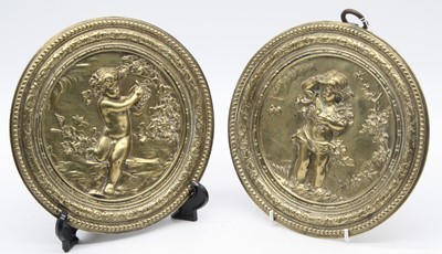 Lot 115 - A pair of brass roundels each relief decorated...