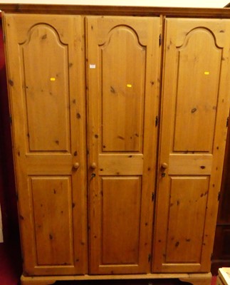 Lot 1194 - A modern Ducal pine three door wardrobe, w.145cm