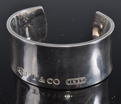 Lot 409 - A Tiffany Co silver bangle, 82.4g, with suede...