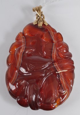 Lot 461 - A Chinese? carved agate pendant, featuring a...