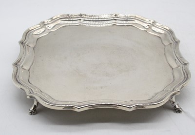 Lot 525 - A George V silver card waiter of shaped square...