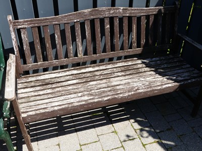 Lot 1450 - A stained and slatted teak three-seater garden...