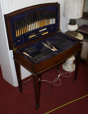 Lot 633 - An Edwardian oak table cutlery canteen, the...