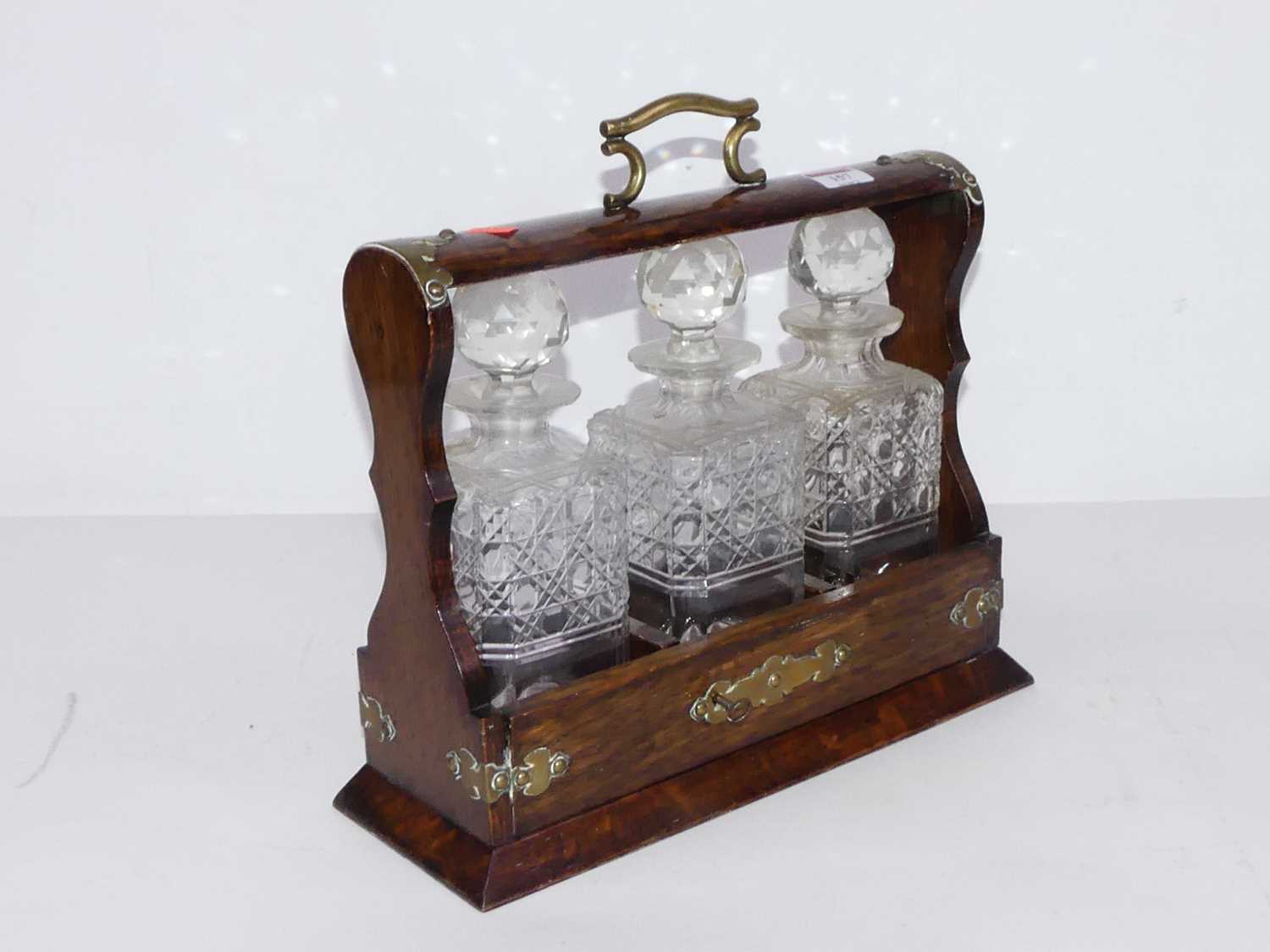 Lot 157 - A 1920s oak and brass mounted tantalus,...