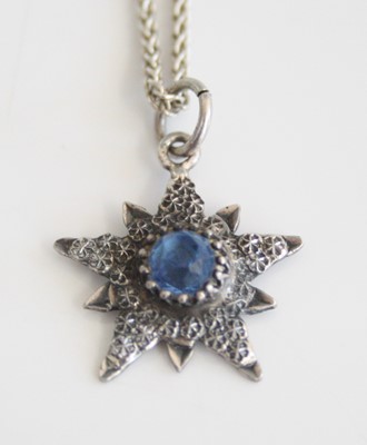 Lot 239 - A sterling silver textured ten-ray star...