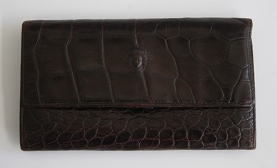 Lot 254 - A Versace crocodile skin wallet, with button...