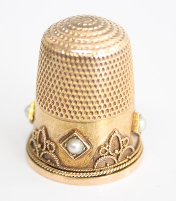 Lot 2232 - A yellow metal pearl set thimble, the four...
