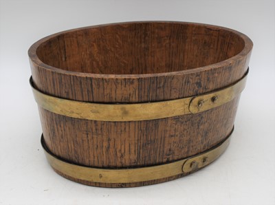 Lot 26 - A brass coopered oak jardiniere, of oval form,...