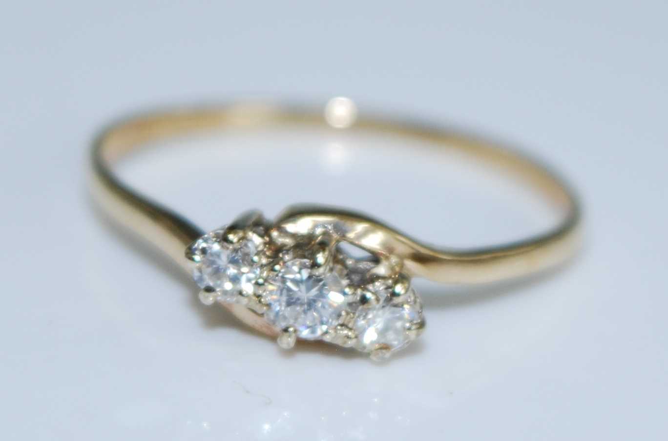 Lot 2561 - A 9ct yellow gold diamond three stone ring,...