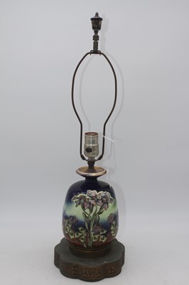 Lot 12 - A tubelined pottery oil lamp on pierced brass...