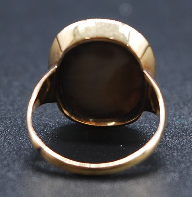 Lot 2615 - A yellow metal carved Lava Stone cameo ring...