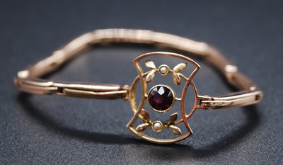 Lot 2613 - A yellow metal, garnet and seed pearl bracelet,...