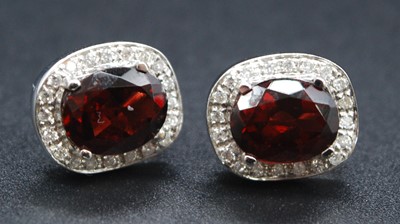 Lot 2627 - A pair of white metal, garnet and diamond oval...