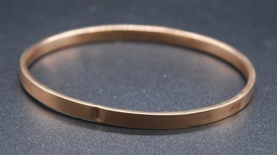 Lot 2632 - A 9ct rose gold hollow bangle, of square...