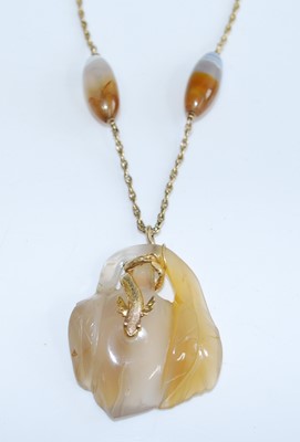 Lot 454 - A carved agate pendant with yellow metal sea...