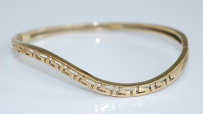 Lot 2747 - A yellow metal hinged bangle, of wavy outline,...