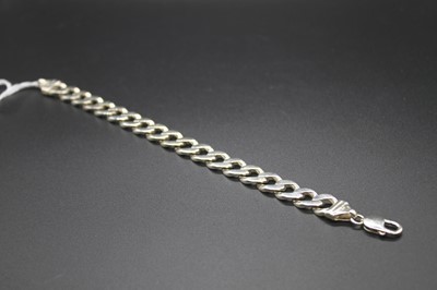 Lot 475 - A modern silver gents flat curb link bracelet,...