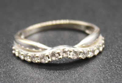 Lot 289 - A modern white metal and diamond set half hoop...