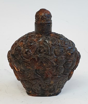 Lot 2413 - A Chinese amber snuff bottle, profusely carved...