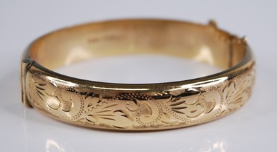 Lot 2249 - A 9ct yellow gold oval hinged bangle, half...