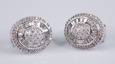 Lot 2287 - A pair of 18ct white gold diamond oval cluster...