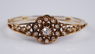 Lot 2200 - A yellow metal diamond set hinged bangle, the...