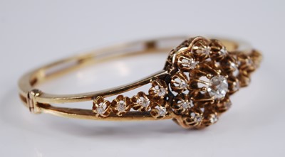 Lot 2200 - A yellow metal diamond set hinged bangle, the...