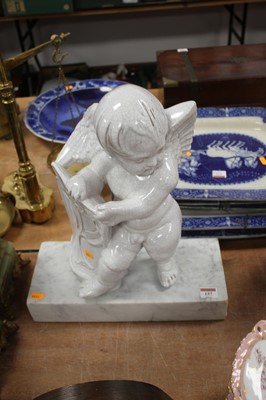 Lot 157 - A continental pottery putto, mounted upon a...